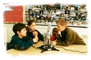 Students manipulating a robotic arm in the classroom